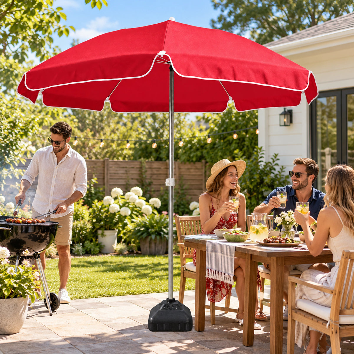 Burgundy red patio umbrella with water-fill base shading a backyard barbecue and dining table